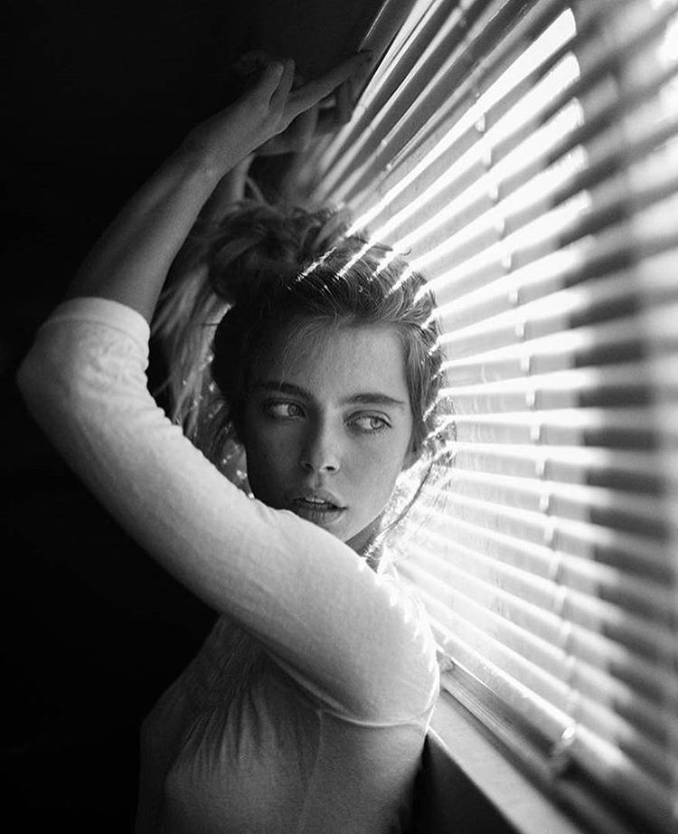 Indoor portrait of a woman near a window with soft natural light